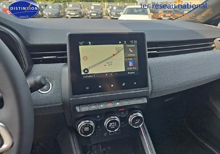 Vue intérieure centrée sur la console centrale et l'écran tactile du tableau de bord de la Renault Clio V gris schiste.