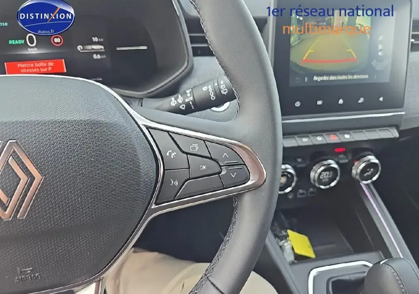 Vue intérieure centrée sur le volant multifonction et l'écran tactile du tableau de bord de la Renault Clio V gris schiste.