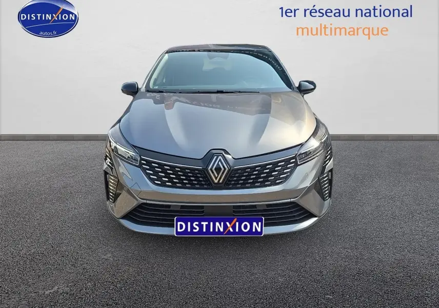 Vue frontale d'une Renault Clio V gris schiste avec calandre chromée et phares LED allumés.