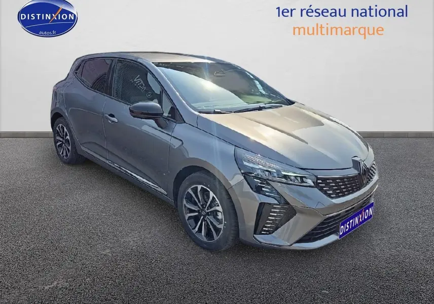 Renault Clio V gris schiste vue 3/4 avant gauche, avec jantes alu et calandre chromée visible.