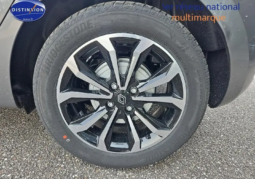 Gros plan sur la jante alu bicolore avec logo Renault d'une Renault Clio V gris schiste, vue côté droit.