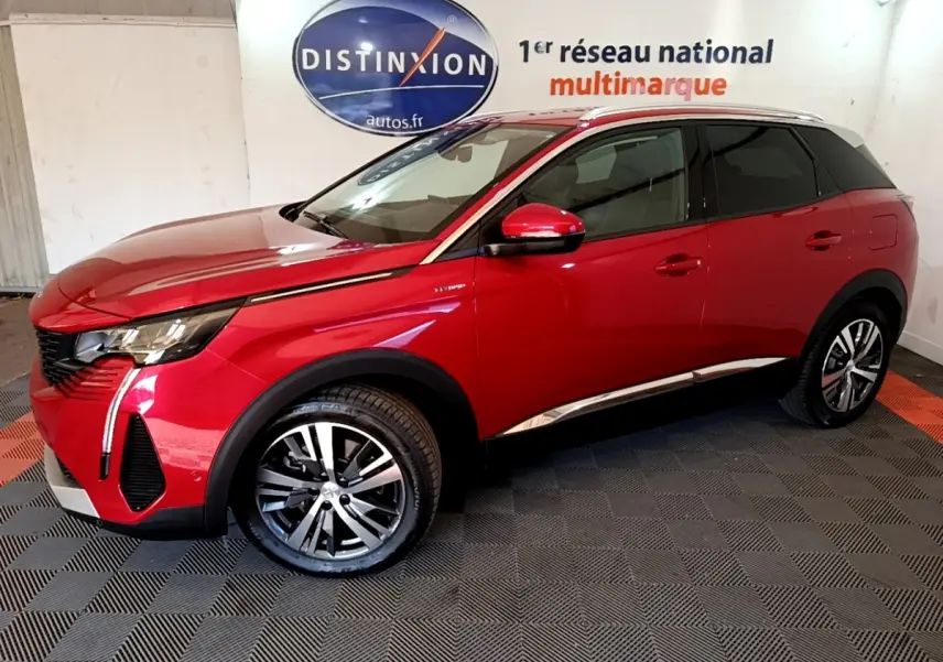 Vue 3/4 avant droit d’un Peugeot 3008 hybride rechargeable rouge avec jantes alliage et détails chromés sur fond intérieur showroom.