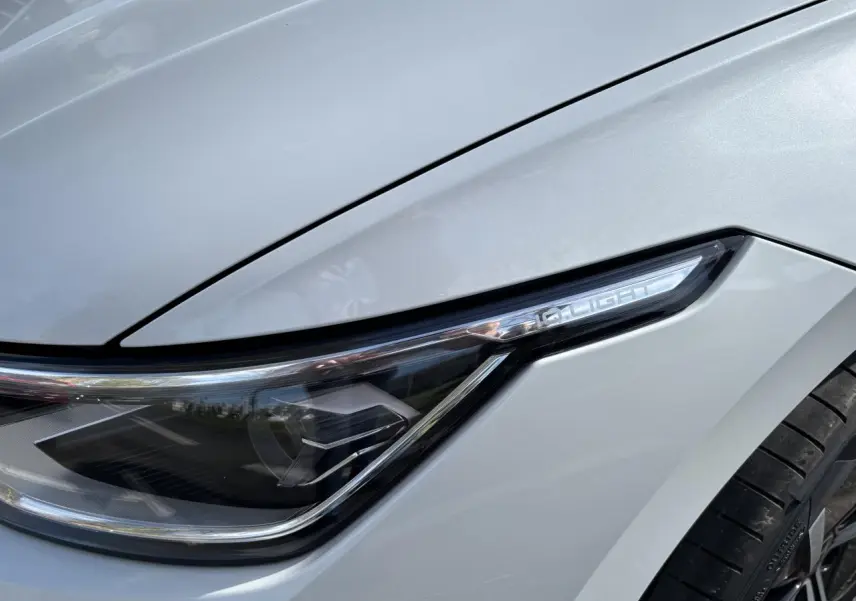 Gros plan sur le phare avant droit blanc de la Volkswagen Golf 1.5 eTSI Edition 50 2024 avec détails LED distinctifs.