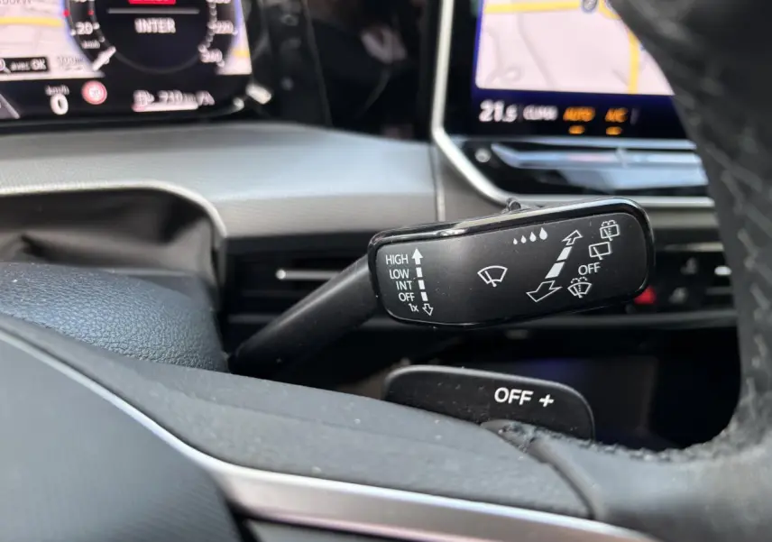 Gros plan sur la commande d’essuie-glace à droite du volant dans l’habitacle d’une Volkswagen Golf blanche 2024.