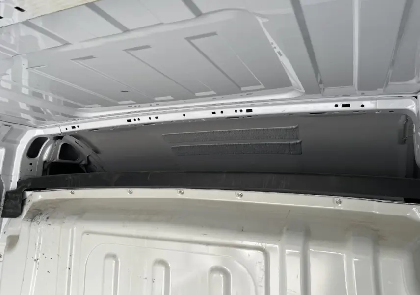 Vue intérieure arrière du Peugeot Boxer Fourgon blanc montrant la cloison tôlée et le plafond du compartiment de chargement.