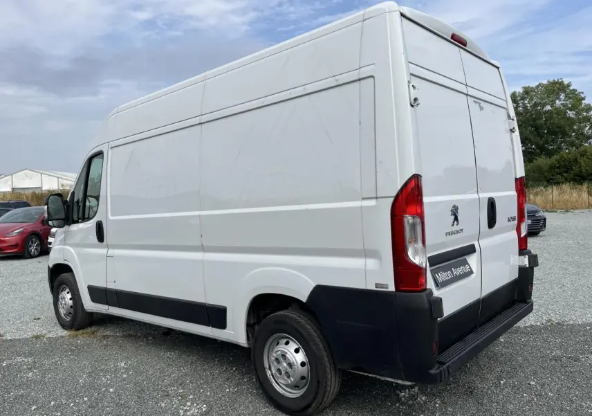 Vue 3/4 arrière droit d’un Peugeot Boxer Fourgon blanc avec portes arrière tôlées et porte latérale coulissante.