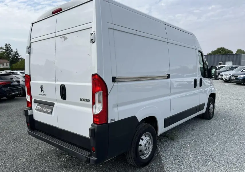 Vue 3/4 arrière droite d’un Peugeot Boxer Fourgon blanc avec portes arrière tôlées et porte latérale coulissante.