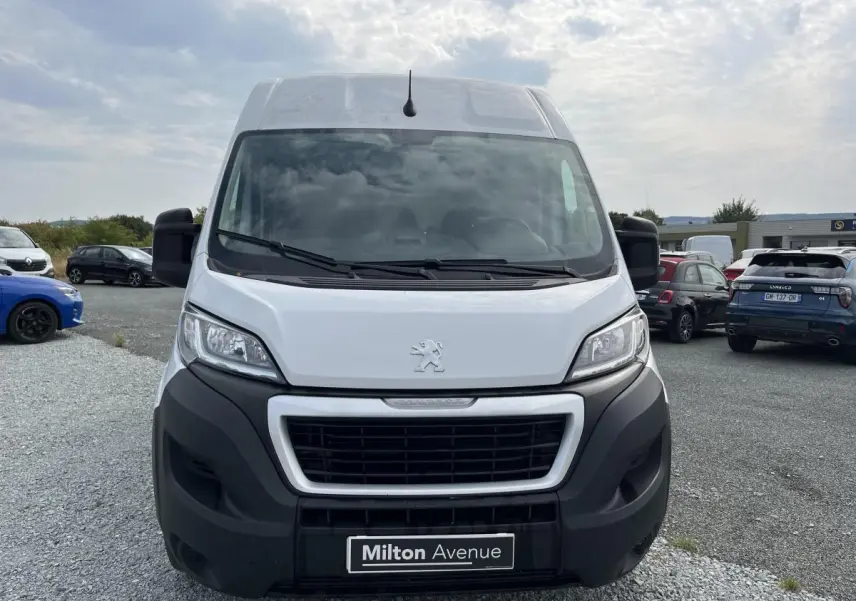 Vue avant d’un Peugeot Boxer Fourgon blanc avec calandre noire et logo lion sur parking extérieur.