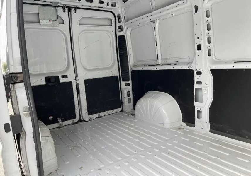 Vue intérieure arrière du Peugeot Boxer Fourgon blanc, montrant l'espace de chargement tôlé avec panneaux noirs.