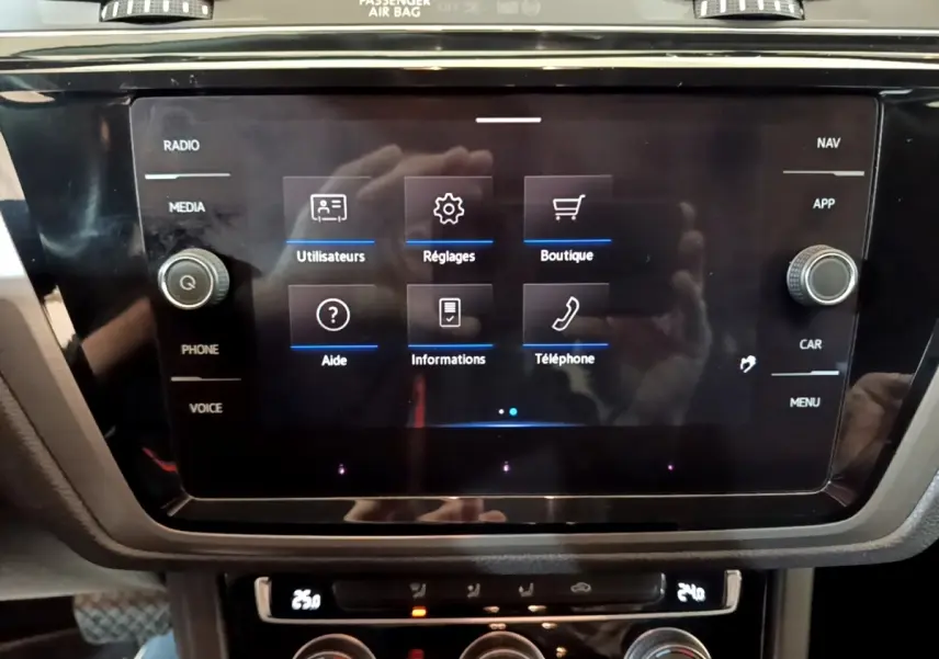 Écran tactile central du Volkswagen Touran 1.5 TSI bleu, affichant menu utilisateurs, réglages et téléphone.