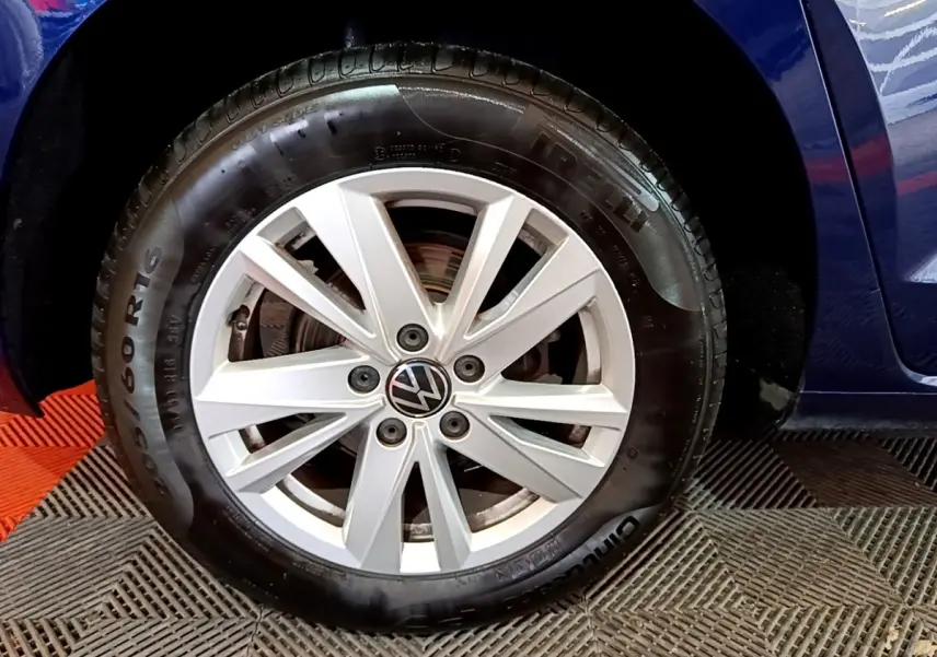 Gros plan sur la roue avant gauche d'un Volkswagen Touran bleu 2021 avec jante alliage et pneu Pirelli.