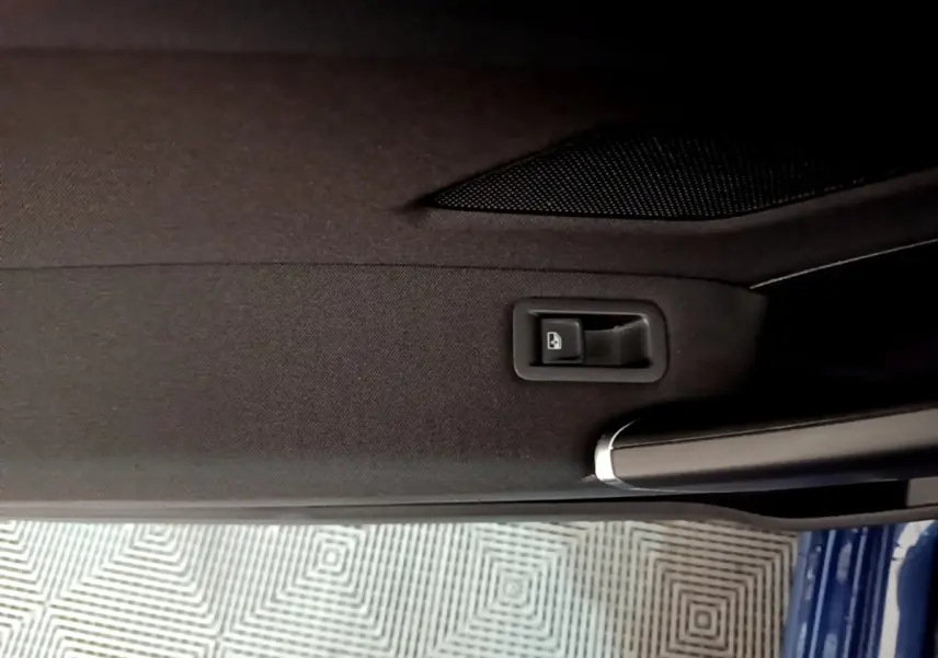 Détail de la poignée intérieure et bouton de verrouillage sur la porte côté gauche d’un Volkswagen Touran bleu 2021