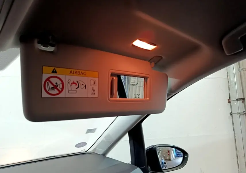 Miroir de courtoisie ouvert sur pare-soleil côté conducteur dans l’habitacle bleu du Volkswagen Touran 2021.