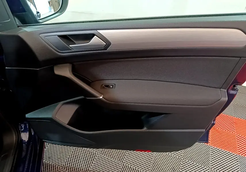 Porte côté gauche ouverte d’un Volkswagen Touran bleu 2021, intérieur noir avec insert décoratif gris.