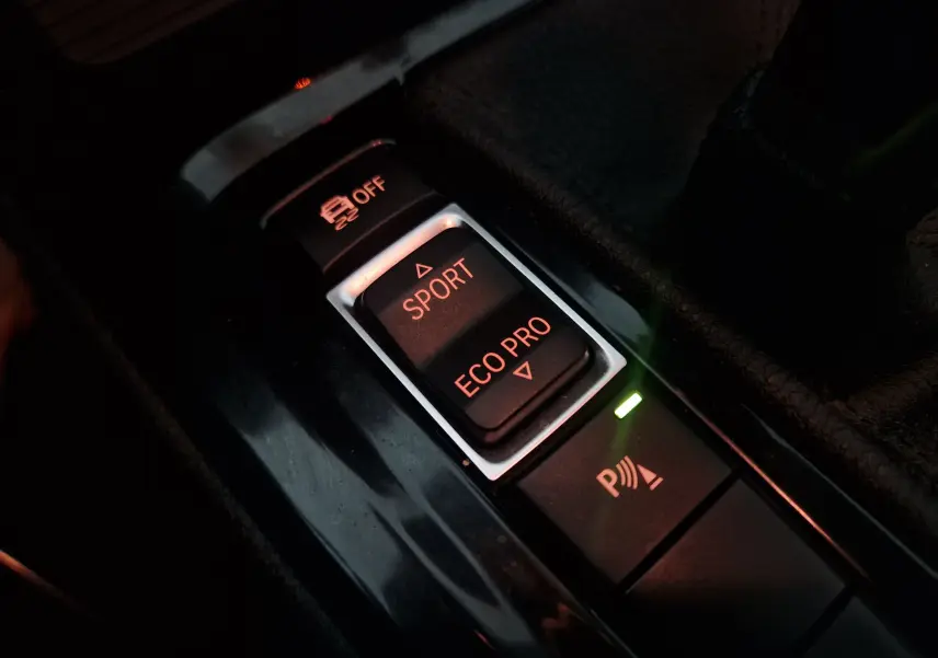 Gros plan intérieur sur les boutons de mode de conduite Sport et Eco Pro du BMW X2 gris clair 2018.