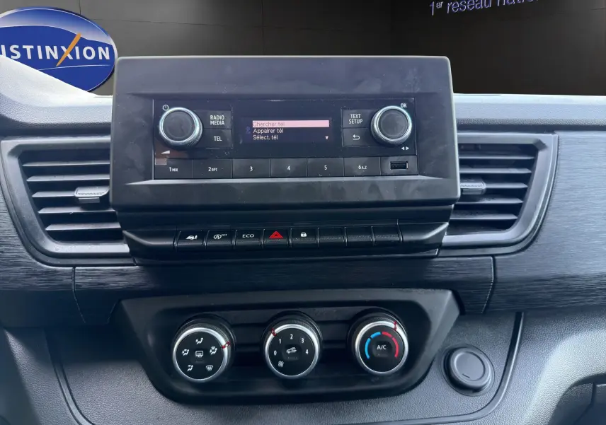 Gros plan sur la console centrale du Renault Trafic Fourgon 2024 avec écran radio et commandes de climatisation.