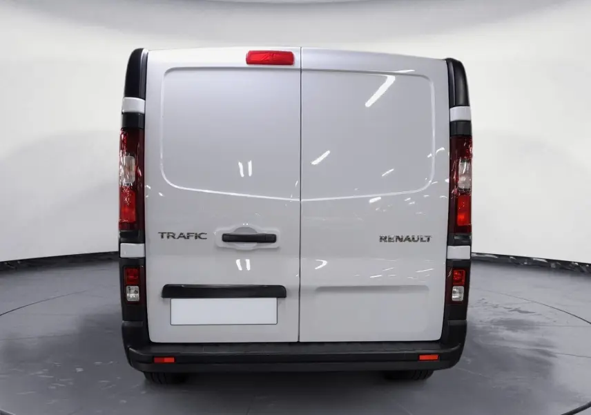 Vue arrière d’un Renault Trafic Fourgon blanc avec portes battantes et feux arrière verticaux visibles.