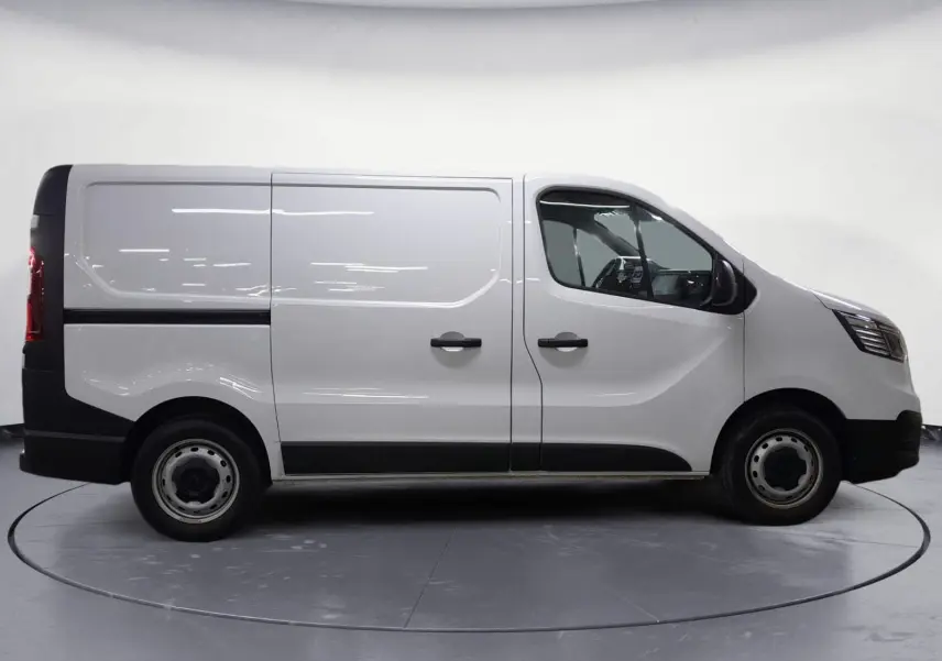 Profil droit du Renault Trafic Fourgon blanc 2024, avec portes latérales et jantes acier simples.