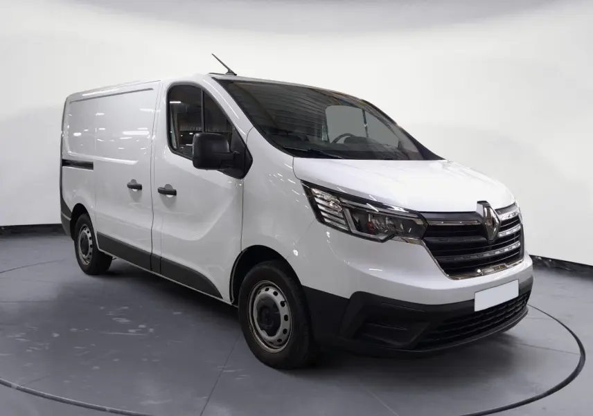 Renault Trafic Fourgon blanc en 3/4 avant droit, avec calandre noire et jantes acier visibles en intérieur showroom.