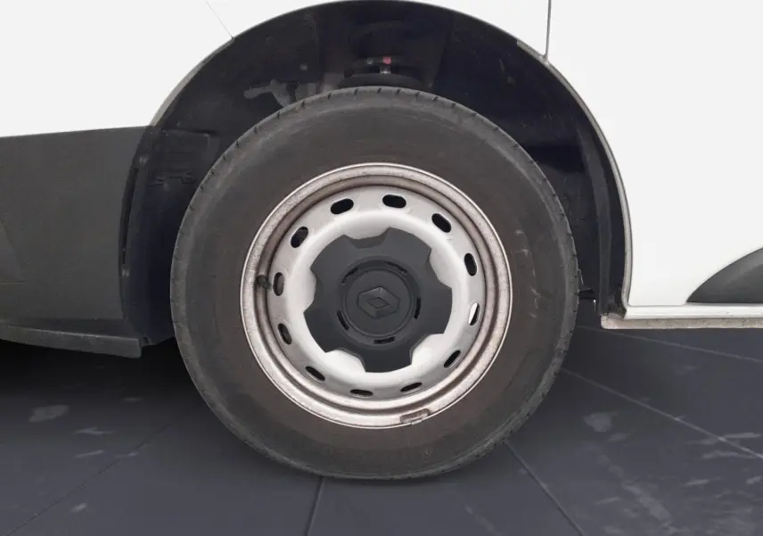 Gros plan sur la roue avant droite blanche d’un Renault Trafic Fourgon 2024 avec jante acier et logo Renault central.