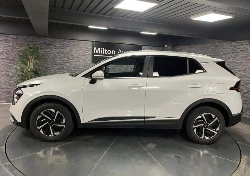 Profil droit du KIA Sportage blanc nacré 2022 avec jantes alliage noires et détails noirs laqués.