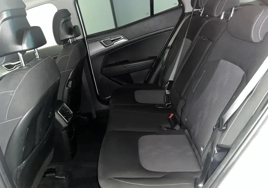 Vue intérieure côté gauche des sièges arrière noirs avec surpiqûres blanches du Kia Sportage blanc 2022.