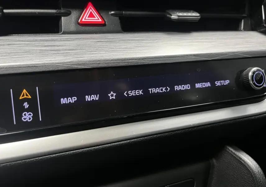Détail de la console centrale du Kia Sportage 2022, écran tactile noir avec commandes multimédia et bouton rotatif.