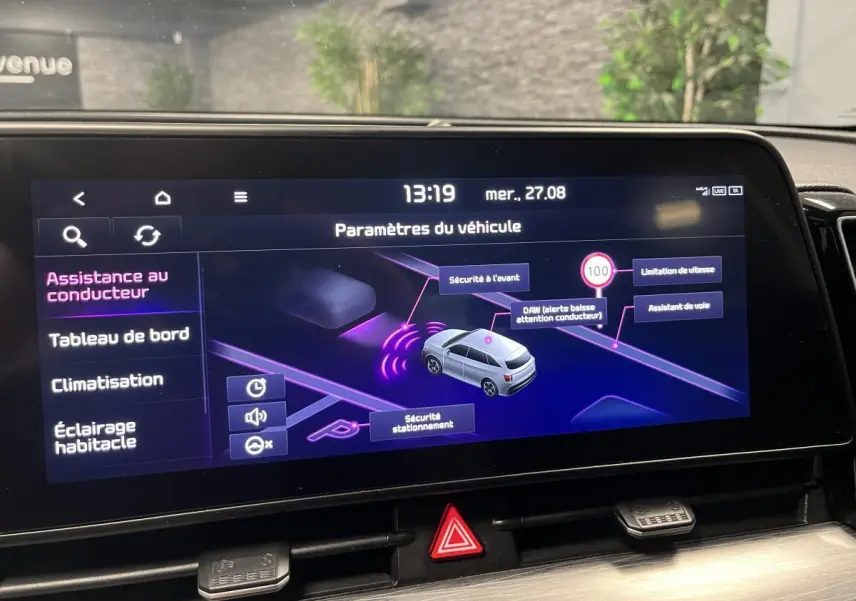 Écran tactile intérieur affichant les paramètres d’assistance du Kia Sportage blanc, vue de face.