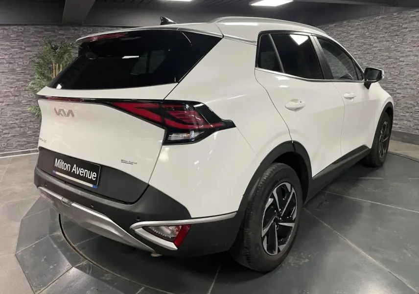 Vue 3/4 arrière droite du KIA SPORTAGE blanc nacré avec feux arrière LED et jantes alliage 18 pouces.