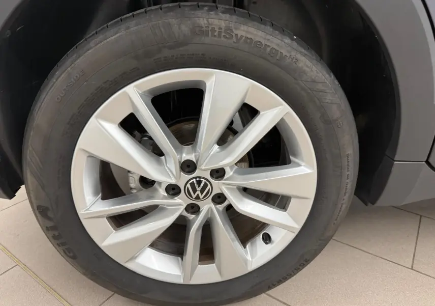 Gros plan sur la jante alliage argentée et le pneu GitiSynergy du Volkswagen T-Cross gris cendre, côté avant droit.