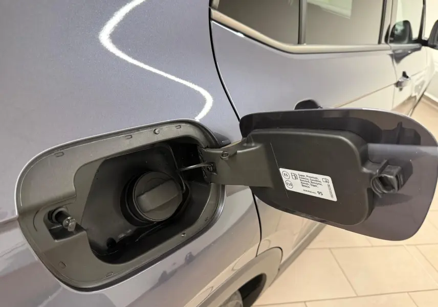 Vue rapprochée de la trappe à carburant ouverte côté gauche du Volkswagen T-Cross gris cendre 2025.