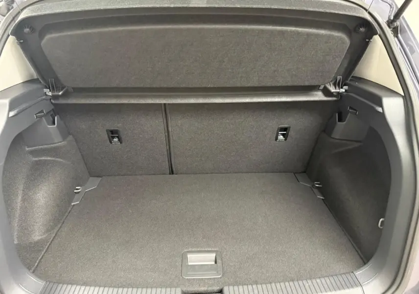 Coffre ouvert du Volkswagen T-Cross gris cendre 2025, montrant l'espace de chargement et la tablette arrière.