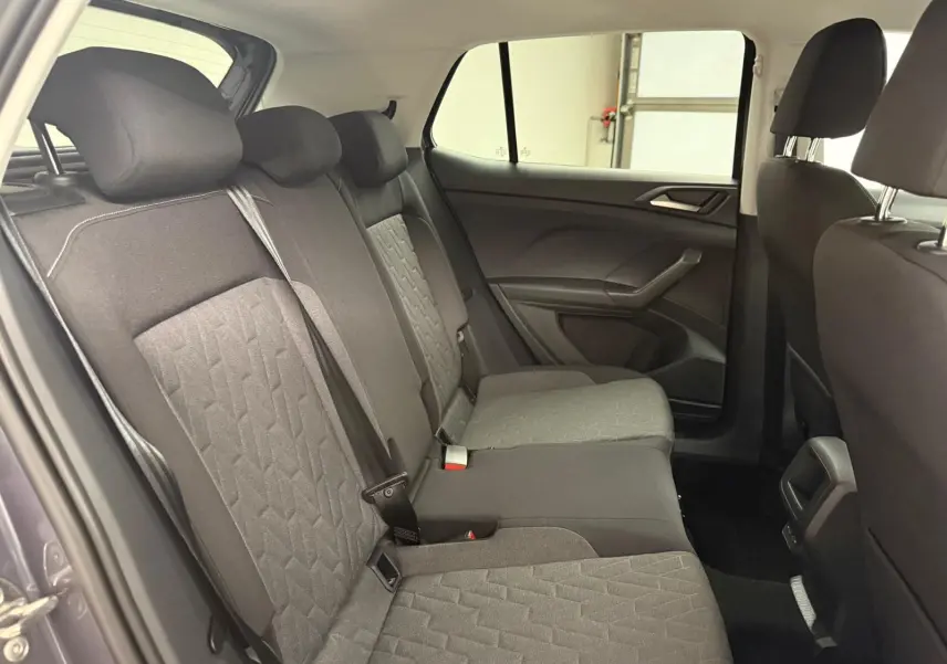 Vue intérieure des sièges arrière du Volkswagen T-Cross 2025 gris cendre, montrant les textures et ceintures de sécurité.
