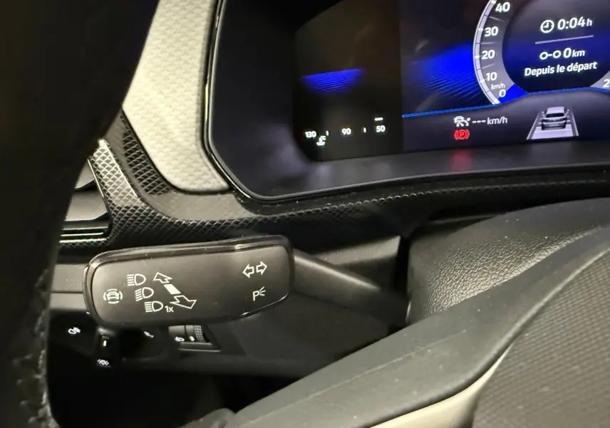 Détail du combiné d'instruments et du commodo gauche du Volkswagen T-Cross gris cendre, vue intérieure côté conducteur.