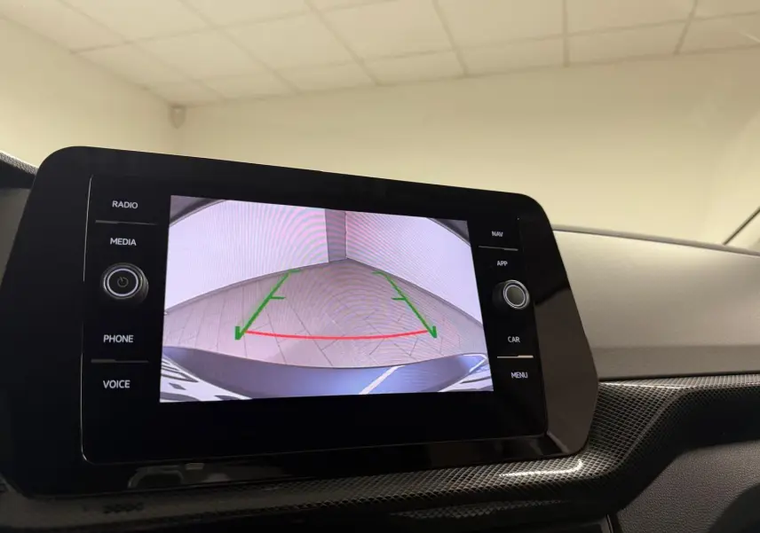 Écran central affichant la caméra de recul d’un Volkswagen T-Cross gris cendre, vue intérieure du tableau de bord.