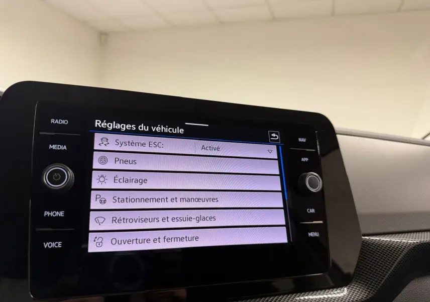 Écran tactile central du Volkswagen T-Cross 2025 affichant les réglages du véhicule dans un intérieur moderne gris.
