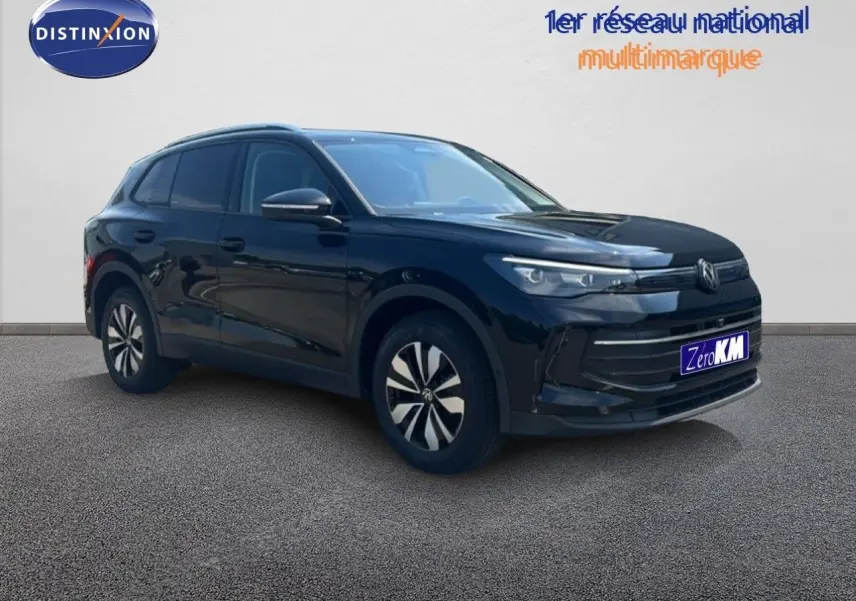 Vue 3/4 avant droit du Volkswagen Tiguan noir Grenadilla métallisé avec jantes spécifiques et calandre épurée.