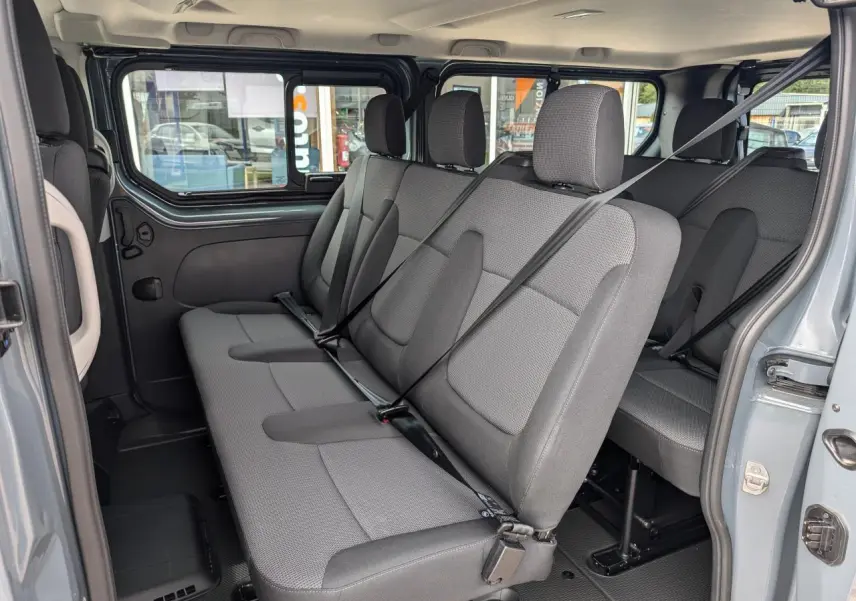 Vue intérieure côté droit sur les sièges gris tissu Kompo Black du Renault Trafic Fourgon L2 2025 avec ceintures attachées.