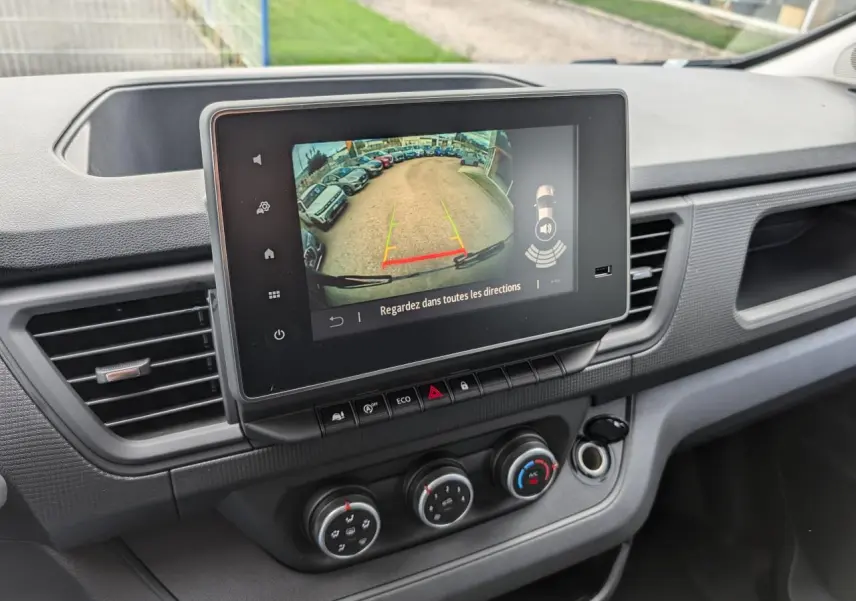 Vue intérieure du tableau de bord du Renault Trafic Fourgon gris 2025, avec écran tactile affichant la caméra de recul.