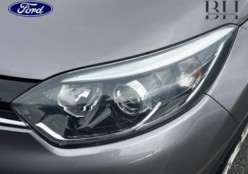 Gros plan sur le phare avant droit du Renault Captur gris Cassiopée, mettant en valeur les détails du bloc optique.
