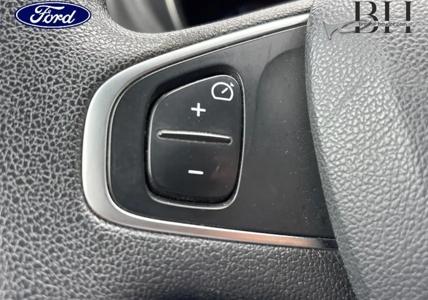 Gros plan sur les commandes de régulateur de vitesse au volant d'une Renault Captur gris Cassiopée.