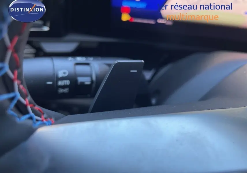 Gros plan sur la palette de changement de vitesse derrière le volant d’un Renault Austral noir étoile métal, intérieur moderne.