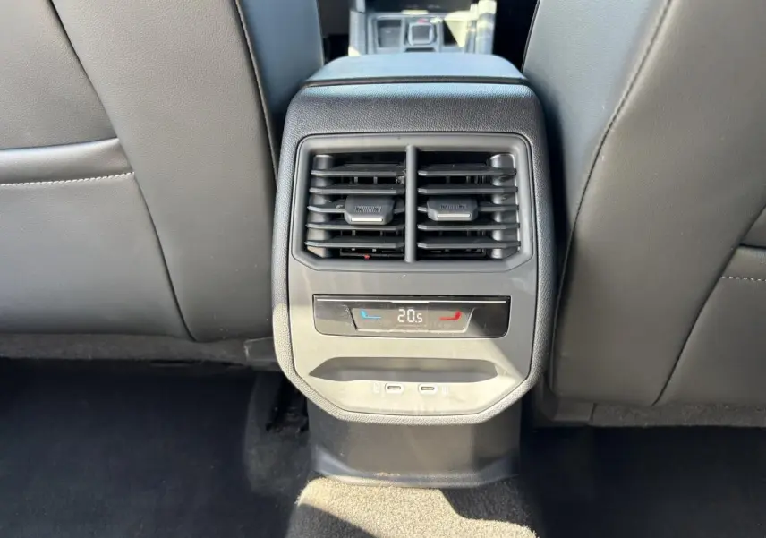 Vue rapprochée de la console centrale arrière avec aérateurs, réglage climatisation à 20,5°C et deux prises USB-C.