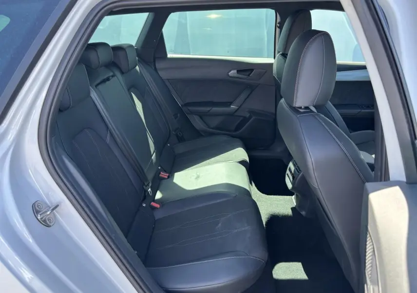 Vue intérieure arrière montrant les sièges noirs et les finitions du CUPRA Leon Sportstourer blanc Nevada 2024.