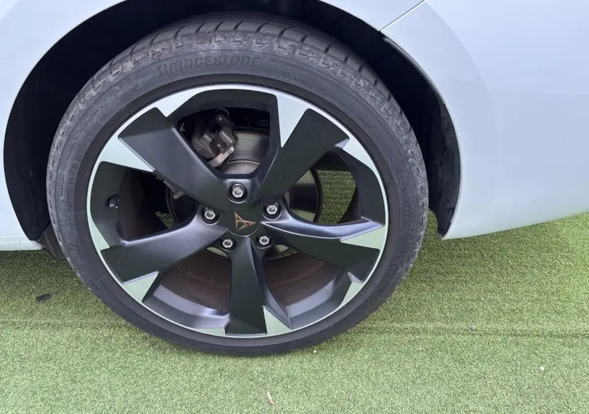 Gros plan sur la jante alliage 18 pouces noire et argentée du côté arrière droit d'une CUPRA Leon Sportstourer blanc Nevada.