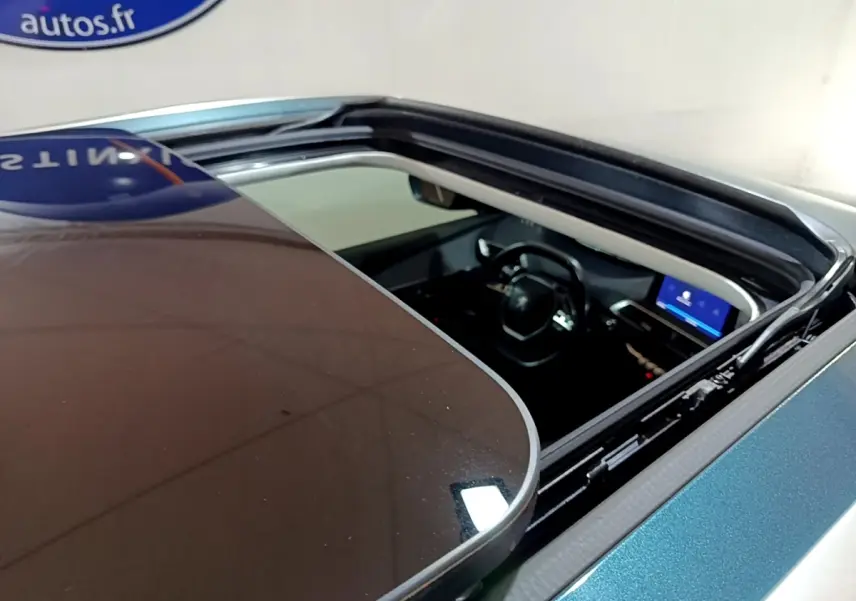 Vue plongeante sur l'intérieur d'un Peugeot 5008 bleu 2018 via son toit ouvrant panoramique ouvert.