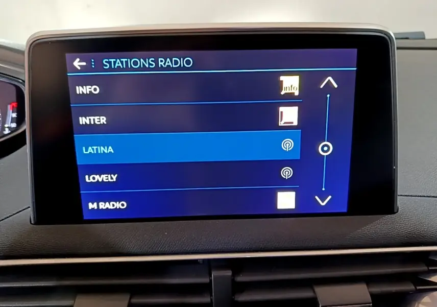Écran tactile central du tableau de bord du Peugeot 5008 bleu, affichant la sélection des stations radio.