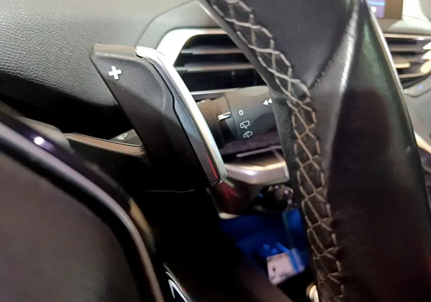 Gros plan sur la palette de changement de vitesse droite en aluminium et cuir du volant du Peugeot 5008 bleu 2018.