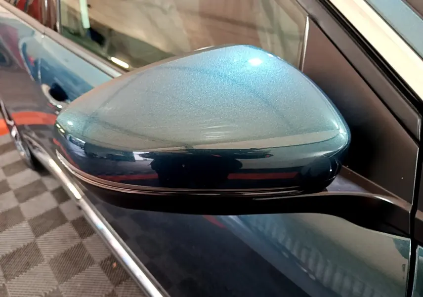 Rétroviseur côté gauche bleu métallisé du Peugeot 5008 2018, avec carrosserie et poignée de porte visibles en arrière-plan.