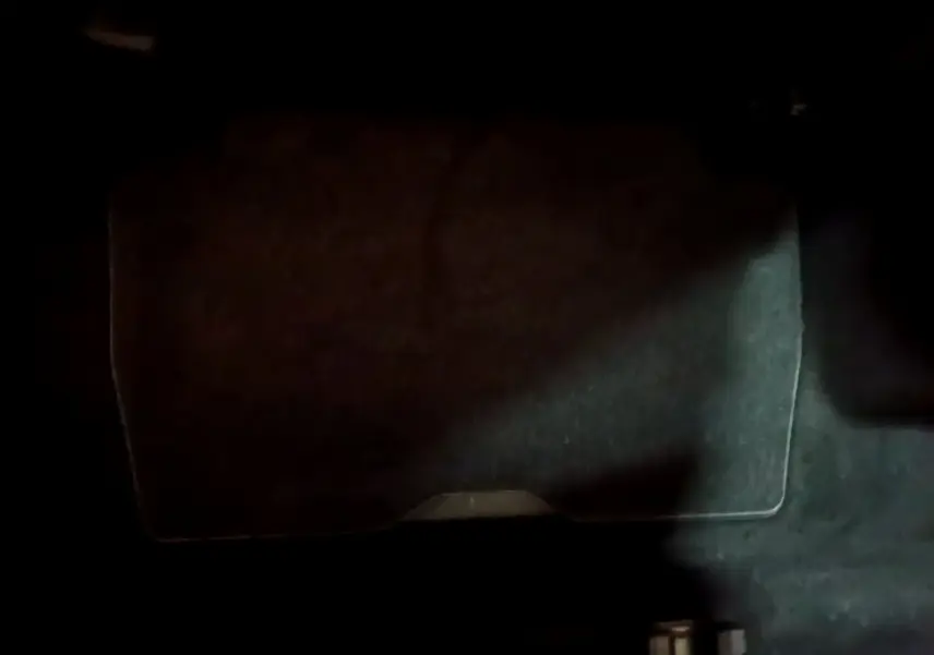 Gros plan sur le coffre avec plancher plat et tapis noir du Peugeot 5008 bleu vue intérieure arrière